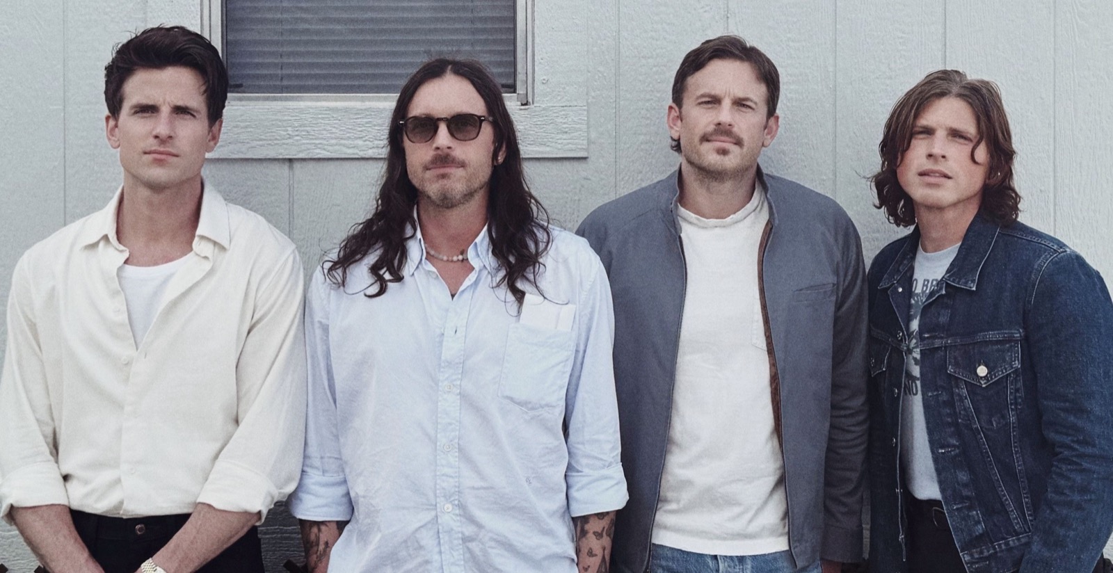 Kings of Leon standing together for a band press photograph.
