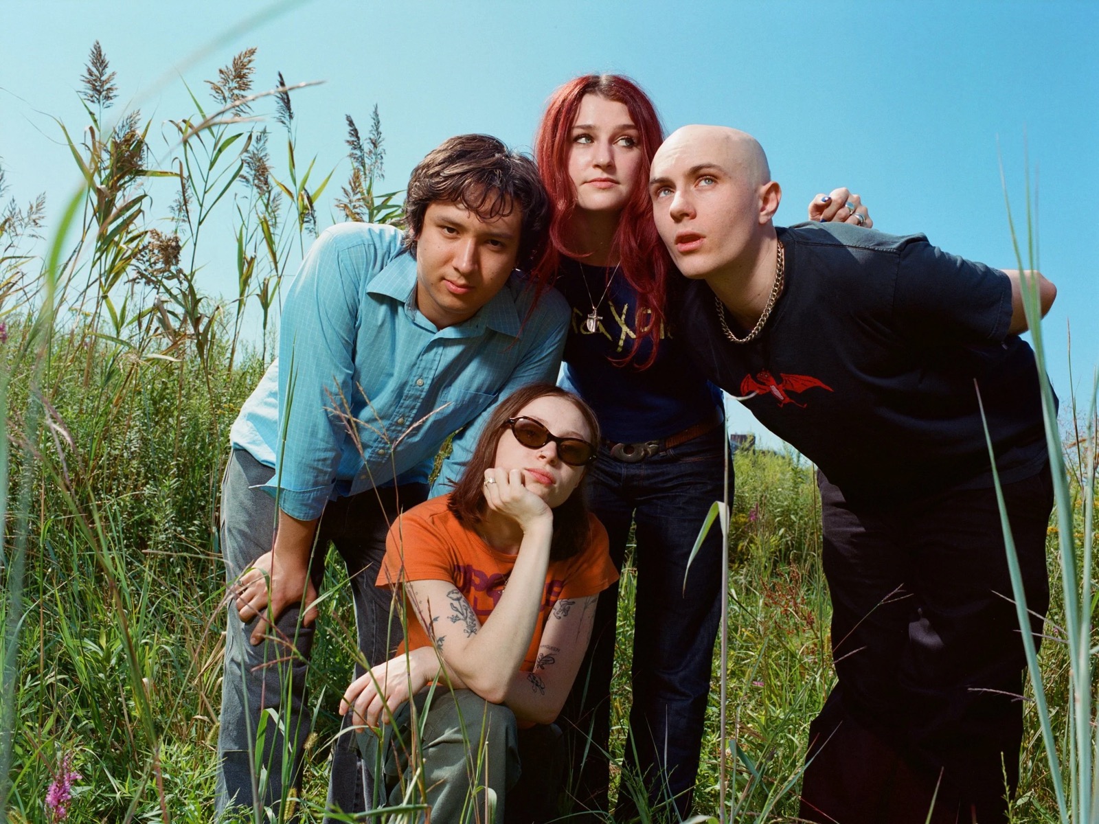 The members of Momma gathered together outdoors in a promotional portrait.