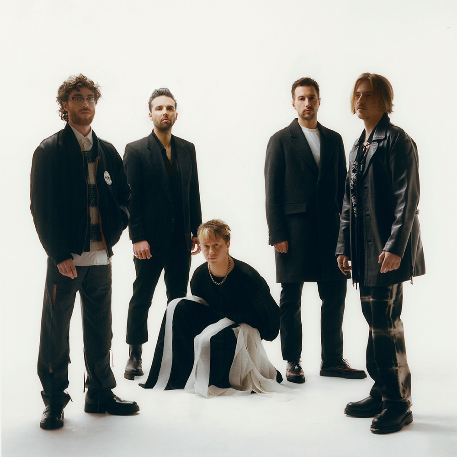 Nothing But Thieves posing together in a clean studio band portrait.