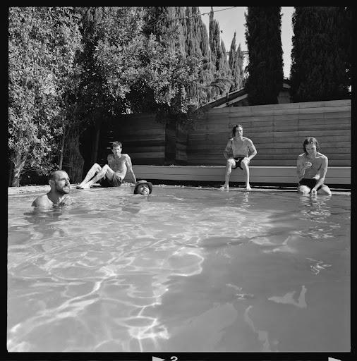 The Neighbourhood photographed together in a black-and-white poolside band portrait.