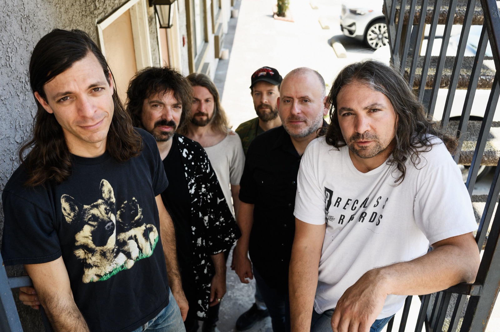 The War on Drugs gathered together outdoors in a band portrait.